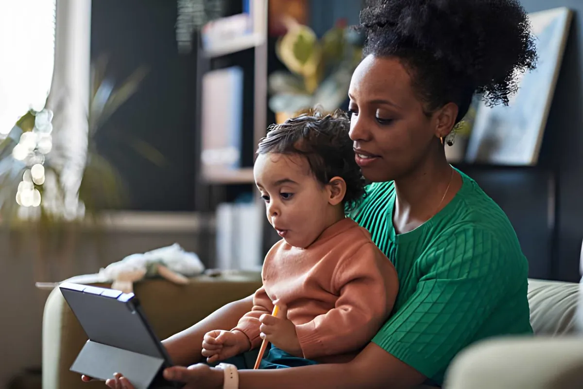 A mother and her toddler looking at a tablet together